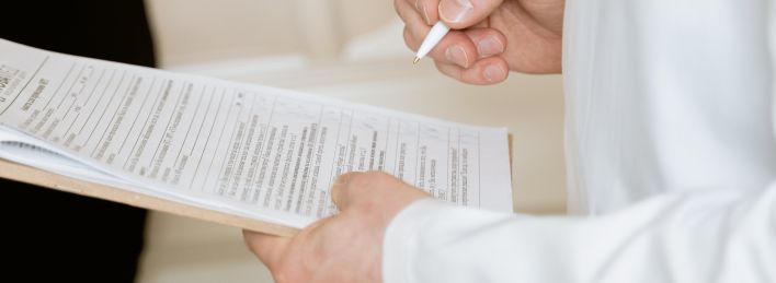 Photo Of Person Holding Paper And Pen